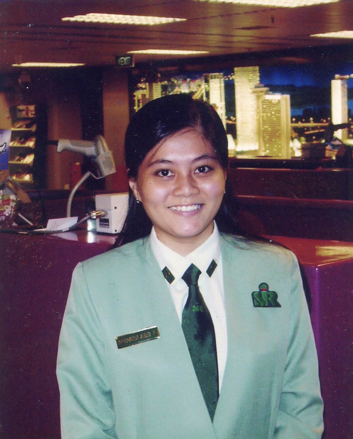 INSP Nuraini wearing the Singapore Immigration & Registration uniform, smiling at the camera