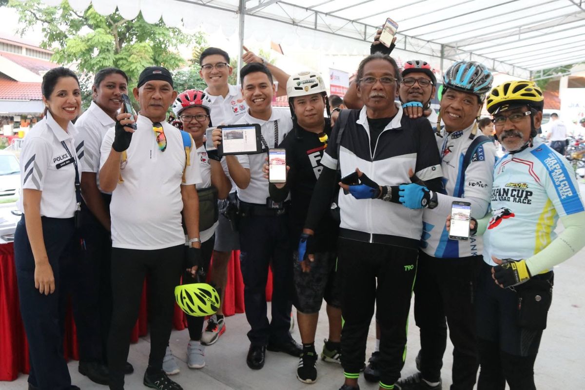 A group of cyclists posing for a group photo with DSP Kiran and another police officer